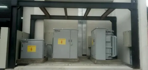 Celdas de transformación de media tensión instaladas bajo una estructura metálica, con carteles de riesgo eléctrico