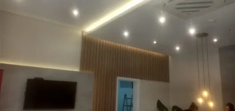 Hall de entrada con luz lineal en el cielorraso, spots embutidos y lámparas colgantes